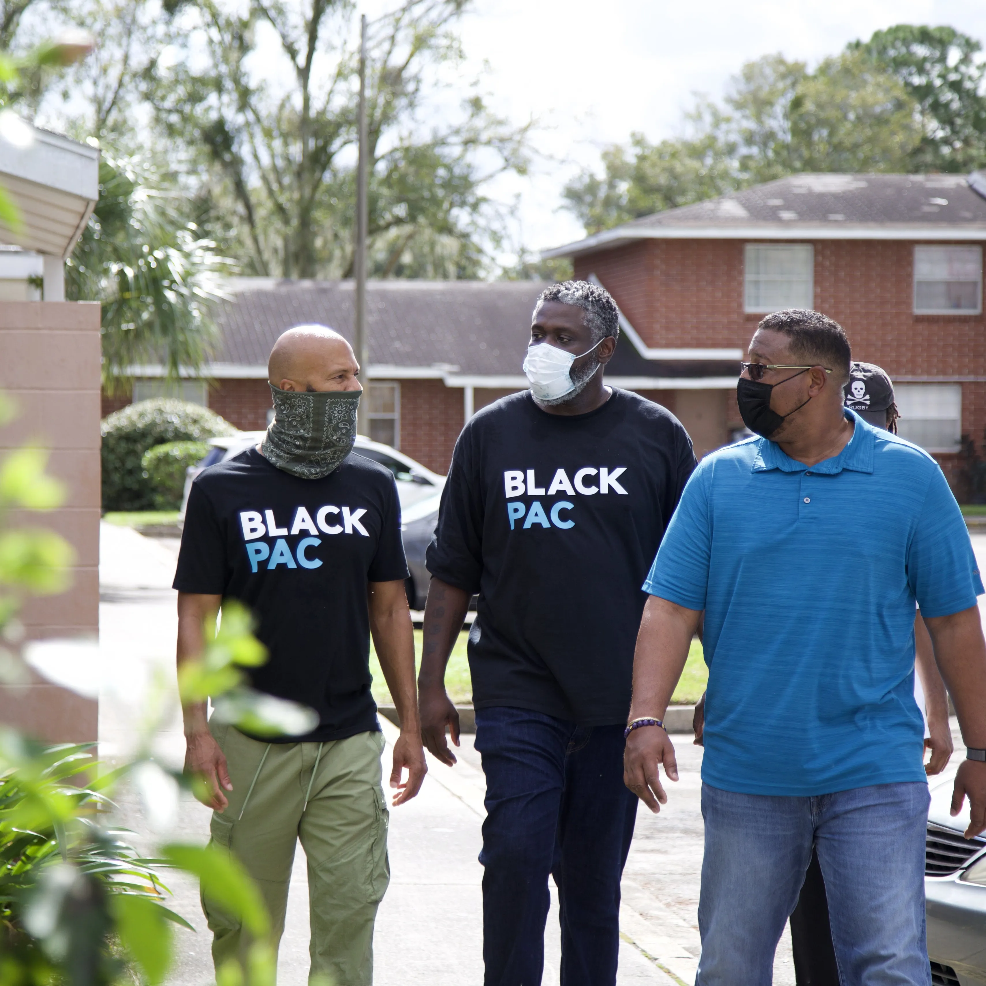 Three BlackPAC canvassers walking through a neighborhood